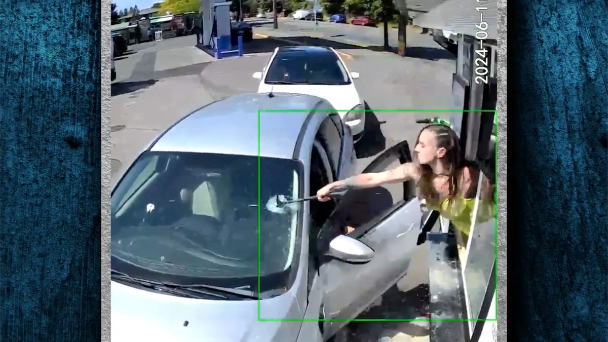 Bikini-clad barista takes hammer to customer’s windshield after he throws coffee at her